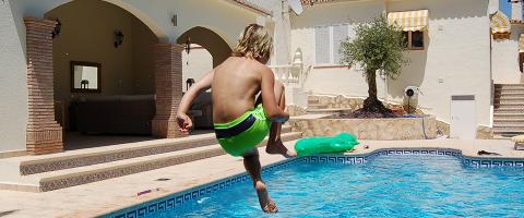 ideale zomervakantie volgens kinderen - kind springt in een zwembad