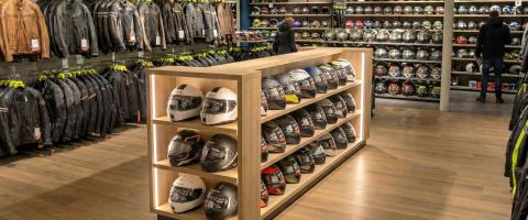 Intérieur d’un magasin spécialisé pour l’équipement moto avec des casques et vestes pour moto.