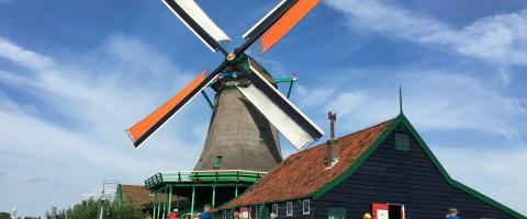 moulin à vent brun et gris près d’un plan d’eau en journée (Zaandam)