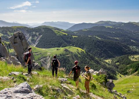 Foto van een meisje in short nabij een blauw meer nabij een bergtop in de Franse Alpen.