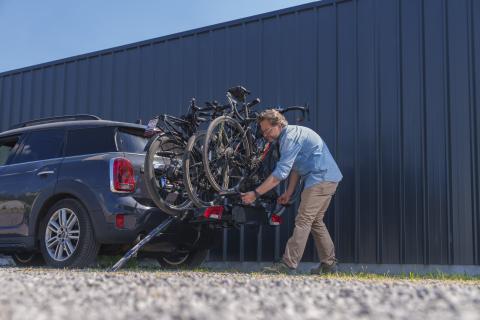 Man bevestigt derde fiets op de Thule EasyFold 3 fietsendrager