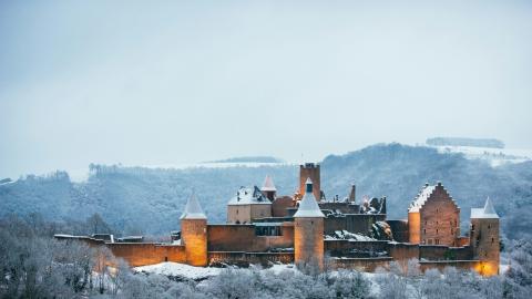 Château de Bourscheid au Luxembourg dans un paysage enneigé.