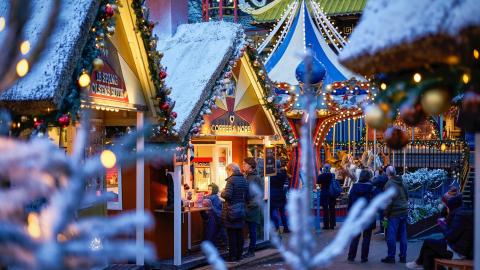 Chalets de Noël illuminés avec toits enneigés.
