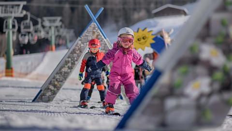 Tout-petits en train de skier sur une piste avec des obstacles.