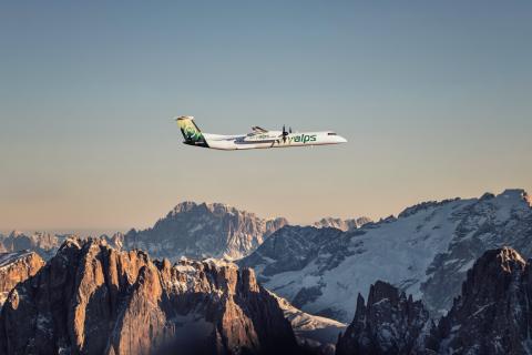 Avion SkyAlps dans le ciel au-dessus des sommets enneigés.
