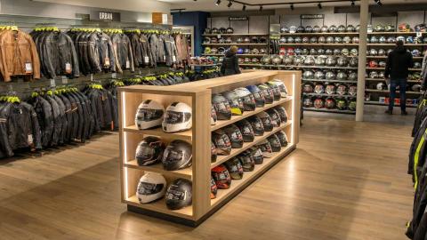 Intérieur d’un magasin spécialisé pour l’équipement moto avec des casques et vestes pour moto.