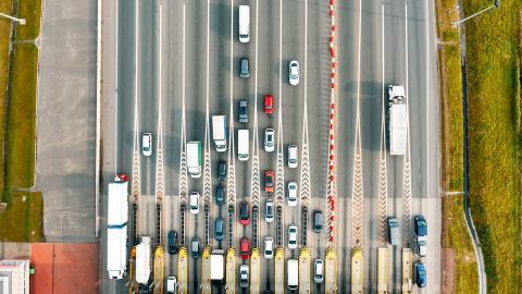 Télépéage: Vue aérienne sur une autoroute à péage où de nombreuses voitures font la queue à un poste de péage.