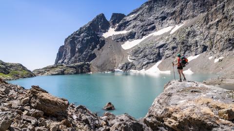 Alpes du Sud jeune ransonneuse devant un lac de montagne.