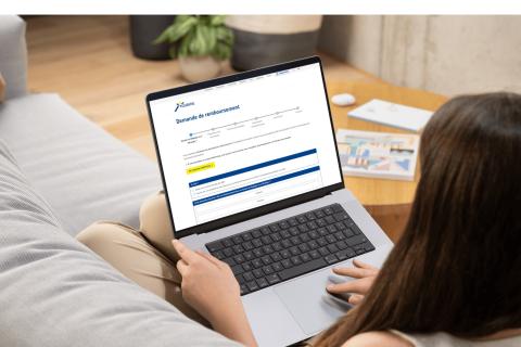 Een vrouw vult een terugbetalingsformulier van Touring in via haar laptop