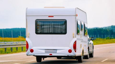 auto met caravan op een brede weg