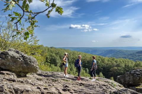 Ardennes françaises trois personnes en randonnée  sur un rocher dans la nature.
