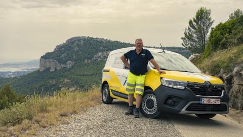 Patrouilleur Touring devant son véhicule de service sur une route de montagne.