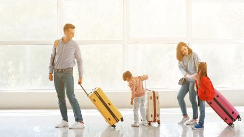 parents avec des enfants et bagage à main à l'aéroport