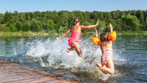 des vacances avec des enfants qui sautent à l'eau depuis un ponton
