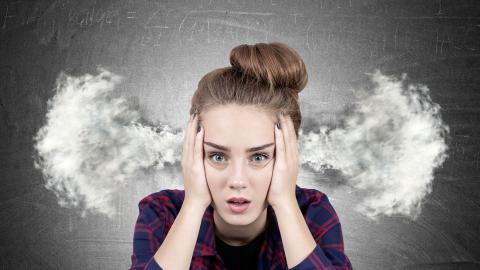 Fatigue: une femme prend sa tête entre ses mains.