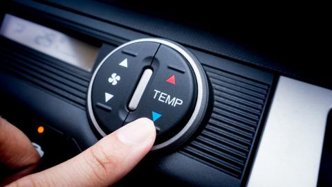 airconditioning: hand die de automatische klimaatregeling op het dashboard van een auto instelt.