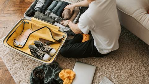 Vacances et bagages: personne remplissant sa valise.