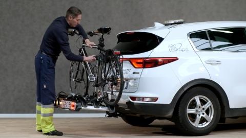 porte-vélos avec 1 vélo sur l'attelage d'une voiture blanche