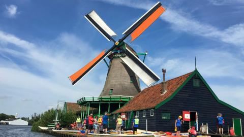 bruin grijze windmolen bij een waterpartij overdag (Zaandam)
